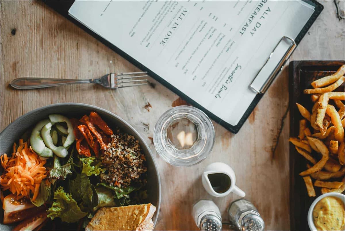 Gedekte tafel met borden met eten en menukaart 