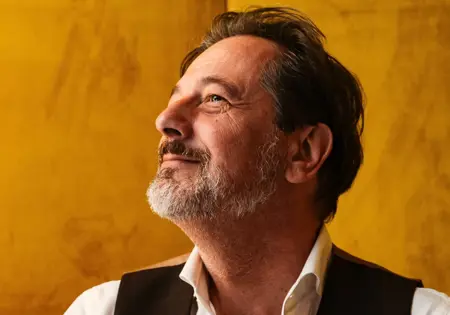 Rik Vera kijkend naar zijkant bij gele achtergrond